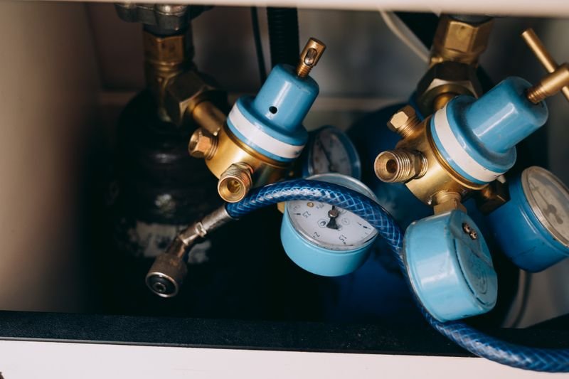 Reguladores de presión de gas con manómetros y conexiones de bronce en una instalación